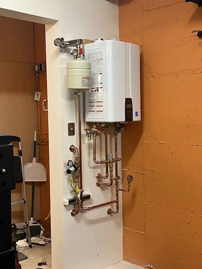 Plumbing technician inspecting water heater connections in West End-Cobb Town